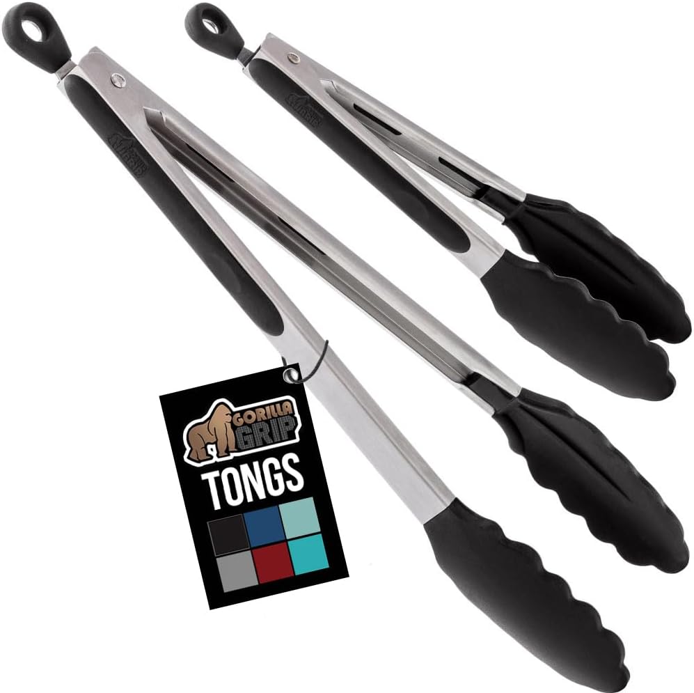 cooking-tongs-set-of-2-stainless-steel-with-black-silicone-tips-7-9-inch-01 Two cooking tongs, one 7-inch and one 9-inch, with brushed stainless steel handles and black silicone tips, in a kitchen sett