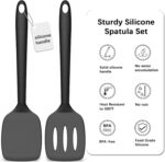 Two PureBlack silicone spatulas, one solid and one slotted, lying on a clean kitchen surface, ready for cooking.