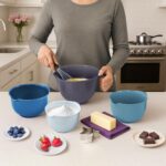 A set of four blue Glad plastic mixing bowls with pour spouts and handles, nested together on a white background.
