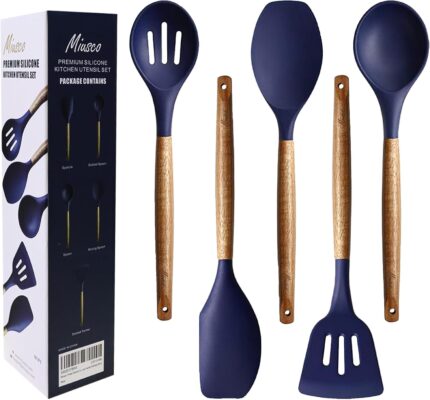 Five midnight blue silicone kitchen utensils with natural acacia wood handles, including a spoon, spoonula, spatula, turner,