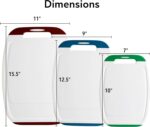 A set of three multicolored Neoflam plastic cutting boards with non-slip handles and juice grooves, stacked on a kitchen coun