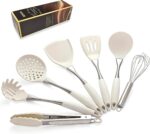 A set of white silicone cooking utensils with stainless steel handles, including a spatula, ladle, spoon, whisk, and tongs.