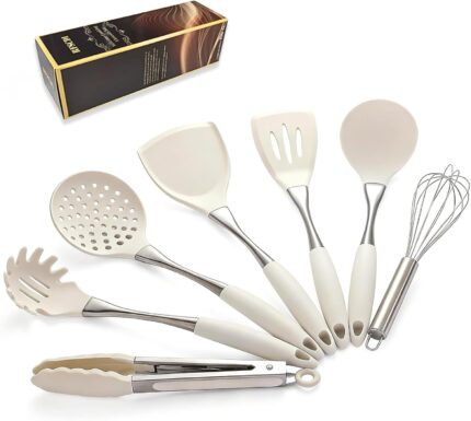 A set of white silicone cooking utensils with stainless steel handles, including a spatula, ladle, spoon, whisk, and tongs.