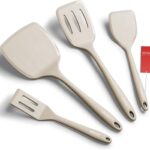 A set of four khaki silicone spatulas of varying sizes, including a slotted and a pancake spatula, on a neutral background.